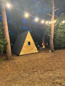 a wooden tent sitting in the middle of a forest at Little Brook Glamping in Salfords