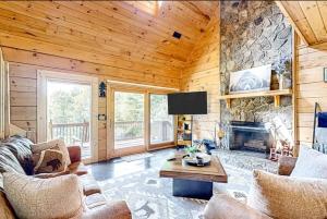 a living room with a stone fireplace in a cabin at Grandpa John Cabin - Hot Tub, Game Room in Sugar Grove