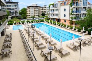 a swimming pool with lounge chairs and a hotel at Hotel Laguna Park Sunrise in Sunny Beach