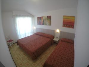 a hotel room with two beds and a window at Residence Zenith - Agenzia Cocal in Caorle