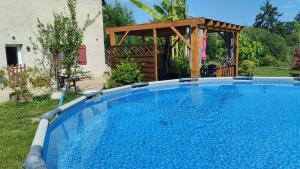 a large swimming pool in a yard with a gazebo at Chez David et Sonia in Éguzon-Chantôme