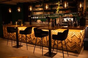 a bar with black chairs and a wooden counter at Hartje Centrum in Zwolle