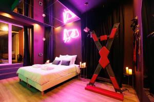 a bedroom with a bed with neon signs on the wall at Love Room Marseille - Aphrodisia in Marseille