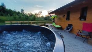 ein mit Wasser gefüllter Whirlpool neben einem Haus in der Unterkunft Chalet Alina in Borşa