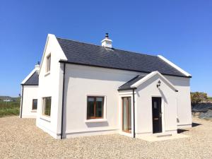 a white house with a black roof at Rannagh View in Liscannor