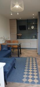 a living room with a blue couch and a table at Alanga in Palanga +11 photos