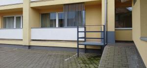 a building with a staircase in front of a window at Alanga in Palanga