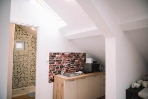 a kitchen with a sink and a brick wall at Casa Alecsandri -Ultra Central in Oradea