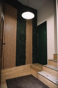 a room with a green wall with a door and stairs at Casa Alecsandri -Ultra Central in Oradea