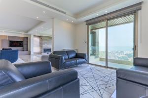 a living room with couches and a large window at Moonlight 2BR In Ain Saade in Beit Meri