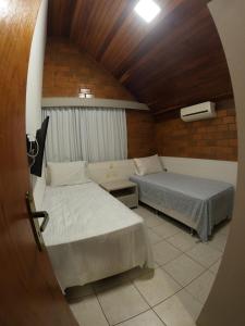 Una pequeña habitación con dos camas y una ventana. en Mount Albuquerque, en Gravatá