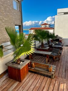a deck with palm trees and chairs on a building at Vila PURA MAYA in Vir