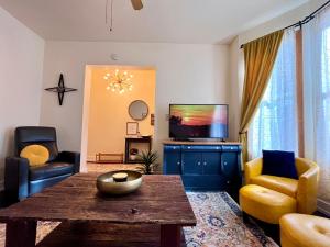a living room with a table and a tv at Relaxing Townhouse Downtown Dubuque in Dubuque