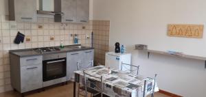 a kitchen with a stove and a table in it at Casa Quokka in Meana di Susa