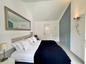 ein Schlafzimmer mit einem großen Bett und einem Spiegel an der Wand in der Unterkunft Villa Marejadilla - Play San Juan - Sleeps 5 - Hot Tub - Sea Views in Playa de San Juan