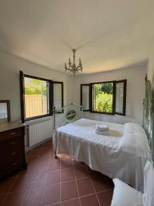 a bedroom with a bed and two windows at Casolare De Ranieri - appartamento in villa bifamiliare a 500m dal mare in Marina di Massa