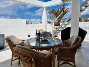 einen Tisch und Stühle auf einer Terrasse mit Weingläsern in der Unterkunft Villa Marejadilla - Play San Juan - Sleeps 5 - Hot Tub - Sea Views in Playa de San Juan