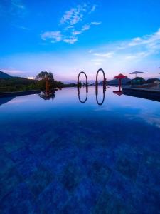 deux miroirs à débordement posés au sommet d'une piscine dans l'établissement Rayana Resort, à Songgoriti