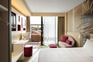 a hotel room with a bed and a chair at Enjoy Garda Hotel in Peschiera del Garda