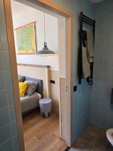 Un baño con un sofá en una habitación con azulejos azules. en Herberg Hanenberg, en Wissenkerke