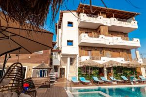 a hotel with a swimming pool in front of a building at Vila Shpetimi in Ksamil