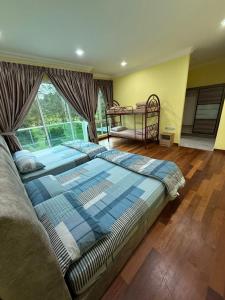 a bedroom with a large bed and a window at Mossy Green Golfcourse Homestay in Tanah Rata