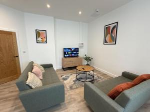 a living room with two couches and a table at Luxury 3 bedroom 2 bathroom All ground floor centrally located - 2 Queen Street - Ashbrook Serviced Apartments in Abingdon +7 photos