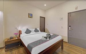 a bedroom with a large bed with a phone on it at Super Townhouse OAK YMCA Ground in Chennai