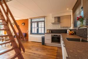 a kitchen with a sink and a stove top oven at Groenendijk Verhuur Zomerhof 2 in Ouddorp