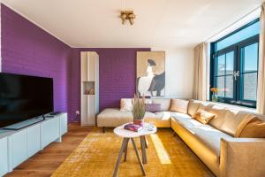 a living room with a couch and a tv at Groenendijk Verhuur Zomerhof 2 in Ouddorp