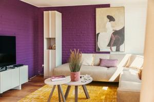 a living room with purple walls and a couch at Groenendijk Verhuur Zomerhof 2 in Ouddorp +18 photos