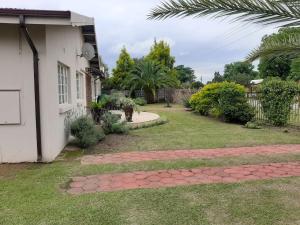 a yard with a brick walkway next to a house at Faraaz BnB in Ladysmith