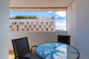 a glass table and chairs in a room with a window at BSB STAY Torre Flats Particulares - Mercure Líder in Brasilia