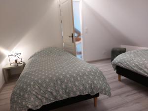 a bedroom with two beds and a door to a room at Gite du soleil in Sémeries