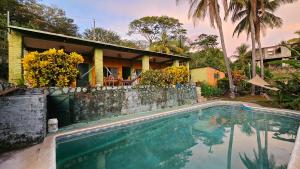 a house with a swimming pool in front of a house at 4 Amigos El Zonte in El Zonte
