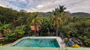 a swimming pool in a resort with palm trees at 4 Amigos El Zonte in El Zonte