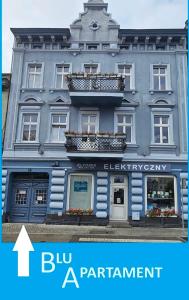 a blue building with a sign that says blu a parliament at Blu Apartament in Strzelno