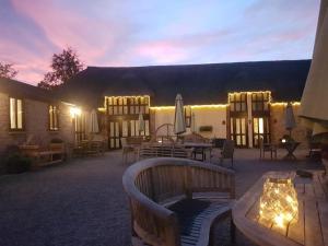 a patio with a table and chairs and lights at Berehayes Cottages in Whitchurch Canonicorum