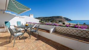 une table et des chaises sur un balcon avec vue sur l'océan dans l'établissement CoolHouses Algarve Luz, 3 Bed Townhouse, central & superb view, Casa Salute (100066/AL), à Luz