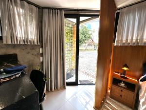 a bedroom with a door open to a yard at Loft para Casal em Bombinhas - Sem Garagem in Bombinhas