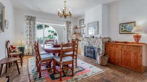 une salle à manger avec une table et des chaises et une cheminée dans l'établissement CoolHouses Algarve Luz, 3 Bed Townhouse, central & superb view, Casa Salute (100066/AL), à Luz