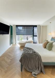 une chambre avec un grand lit et une baignoire dans l'établissement La Casa de las Flores, à Carthagène