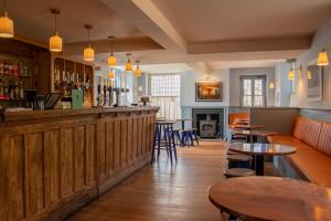 a bar in a restaurant with tables and chairs at The Ship in Brancaster +16 photos