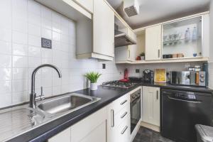 a kitchen with a sink and a dishwasher at Spacious Wembley Flat Comfy Beds 2 Baths in London