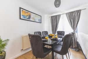 a dining room with a black table and chairs at Spacious Wembley Flat Comfy Beds 2 Baths in London