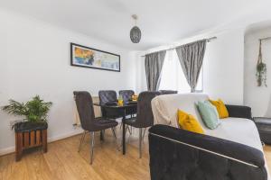 a living room with a table and a couch at Spacious Wembley Flat Comfy Beds 2 Baths in London
