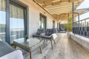 a patio with a couch and chairs and a table at Vision apartmani Vrnjačka Banja in Vrnjačka Banja