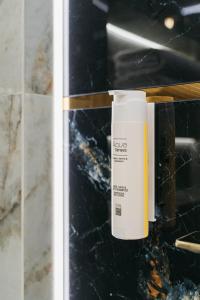 a bottle of sunscreen sitting on a counter in a bathroom at Native Apartments Kościuszki 39I27 in Kraków