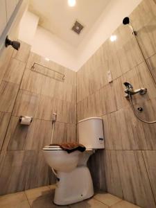 une salle de bain avec toilettes et douche dans l'établissement Rayana Resort, à Songgoriti