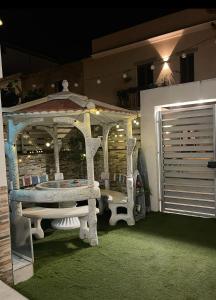 a white gazebo with a bench and a garage at Sea Elegance in Oliveri